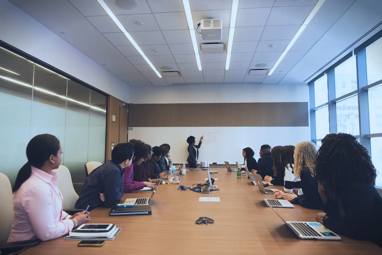 A team listening to a presentation in a long boardroom