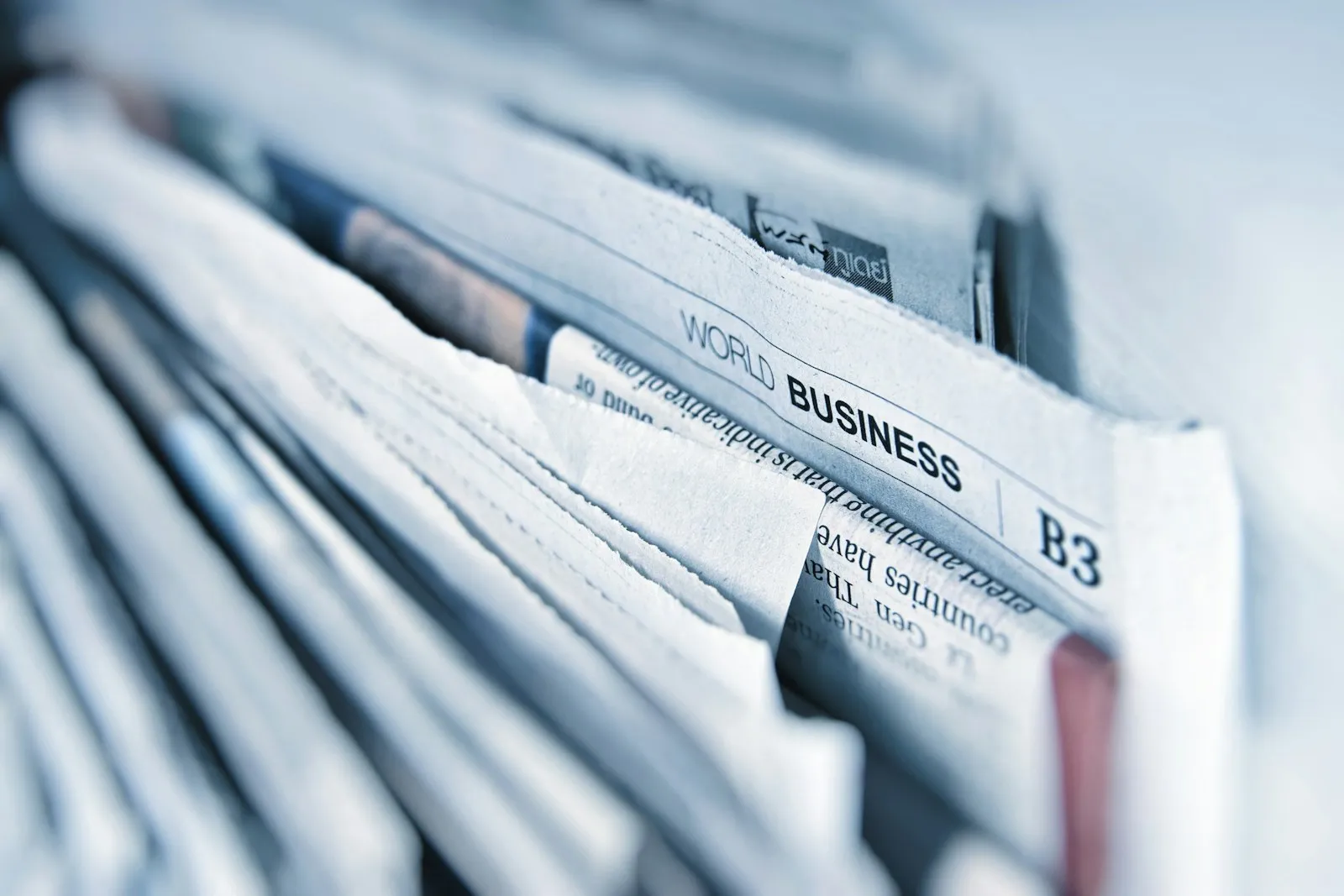 A stack of newspapers folded to the business section