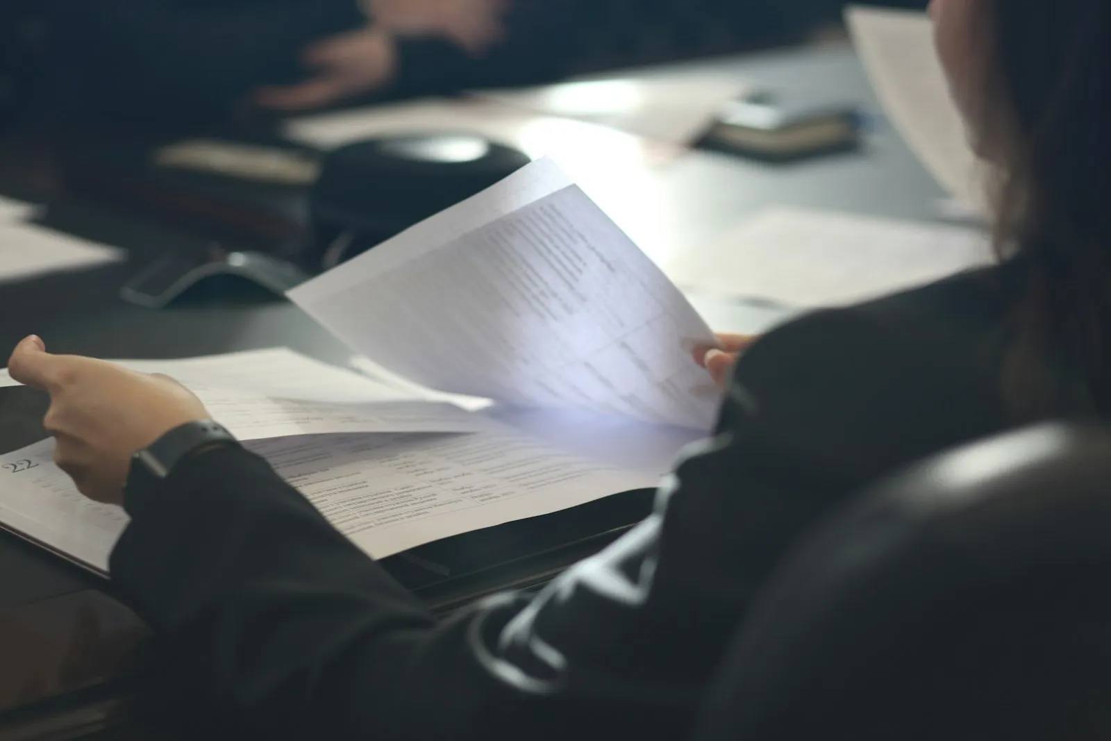 A lawyer reading through a document at a dark table